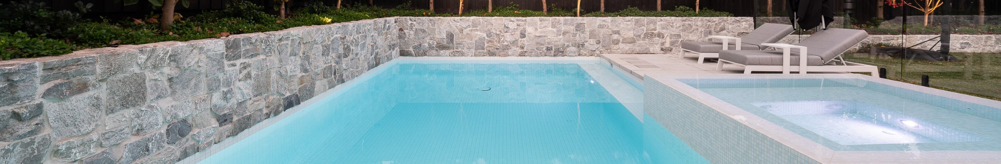 Swimming pool with lounge chairs, showcasing a relaxing outdoor pool area.