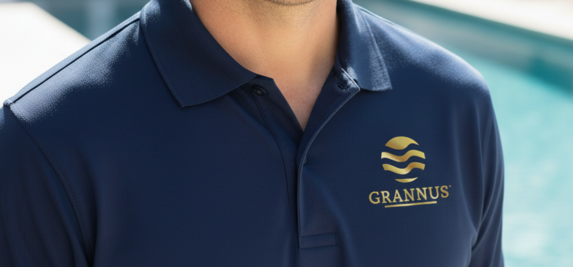 Person wearing navy blue Grannus polo shirt with logo, representing the Grannus team, with blurred background.